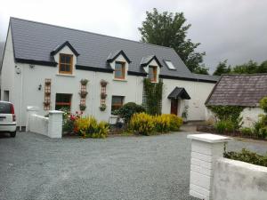 a white house with a black roof at The Glen Farmhouse in Glenfleak