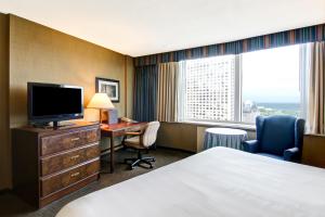 a hotel room with a bed and a desk and a television at Chateau Lacombe Hotel in Edmonton
