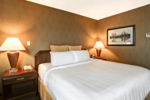 a hotel room with a large bed and two lamps at Chateau Lacombe Hotel in Edmonton