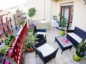 a balcony with chairs and tables and potted plants at I Love Art in Cagliari