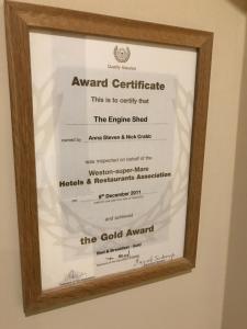 a framed certificate in a wood framed picture of the gold award at The Engine Shed in Weston-super-Mare +1 photo