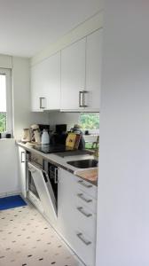 a kitchen with white cabinets and a sink at Ferienwohnung Anita in Annweiler am Trifels