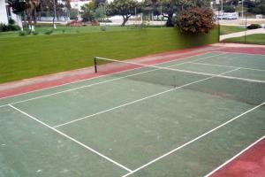 a tennis court with a net on top of it at T1 - Praia da Rocha - com Vistas de Mar e Terraço in Portimão