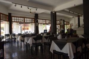 un comedor con mesas y sillas con mantel blanco en Hotel Lantaño en Mar de Ajó