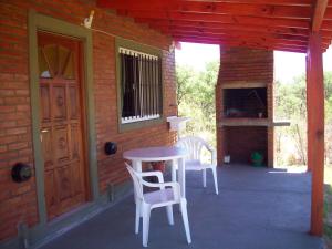 a patio with two chairs and a table and a door at Cabañas Llajta Sumaj in Las Calles