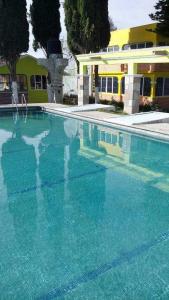 ein großer Pool mit blauem Wasser vor einem Gebäude in der Unterkunft Hotel Cipreses in Ixmiquilpan