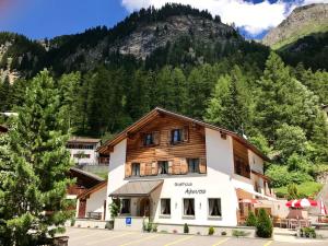 ein Gebäude vor einem Berg in der Unterkunft Gasthaus Alpenrose in Innerferrera