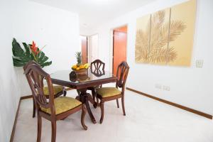 comedor con mesa de madera y sillas en San Fernando Suite 201 - Livin Colombia, en Cali