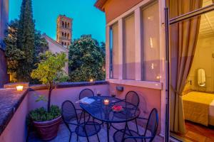 patio con mesa y sillas en el balcón en Aenea Superior Inn en Roma