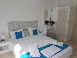 カマリにあるCasa Bellaの白いベッドルーム(ベッドの上に青と白のタオル付)