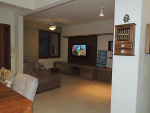 a living room with a couch and a television at Casa Praia Mole in Florianópolis