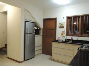 uma cozinha com um frigorífico de aço inoxidável e uma escada em Casa Praia Mole em Florianópolis