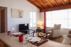 uma sala de estar com uma mesa com copos de vinho em Little Nest en Rancho El Rossinyol em Valle de Guadalupe