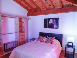 a bedroom with a bed and a picture of a horse on the wall at Little Nest en Rancho El Rossinyol in Valle de Guadalupe