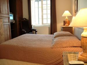 a bedroom with a bed and a table with a lamp at Au Grey d'Honfleur in Honfleur