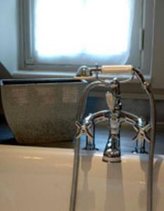 grifo de agua en el baño con lavabo en Au Grey d'Honfleur, en Honfleur