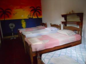 ラス・ペニータスにあるBeach Hostal Oasisの部屋に3つのベッドがあるグループ