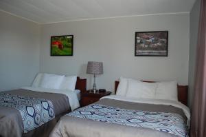 a hotel room with two beds and two pictures on the wall at Edge of the Avalon Inn in Trepassey