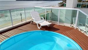 una terraza con una silla y una piscina en Cobertura a Beira da Praia dos Ingleses, en Florianópolis