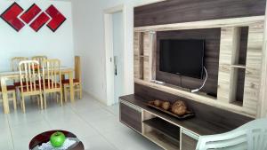 sala de estar con TV de pantalla plana en una pared de madera en Cobertura a Beira da Praia dos Ingleses, en Florianópolis