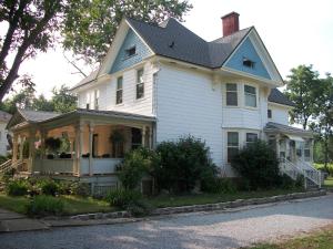 una casa blanca con techo negro en Green Oaks B&B, en Niagara on the Lake