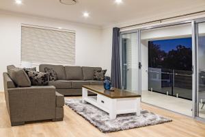 a living room with a couch and a coffee table at Brand New Executive Living 36 in Bundamba
