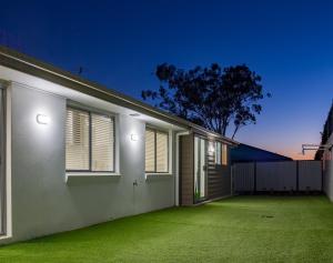 a house with a green lawn in front of it at Brand New Executive Living 36 in Bundamba