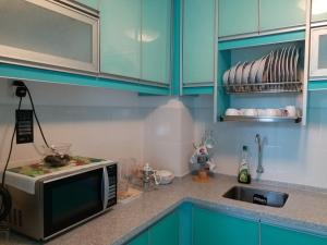 a kitchen with blue cabinets and a microwave at VVIP Homestay Villa Proton City in Tanjung Malim +33 photos