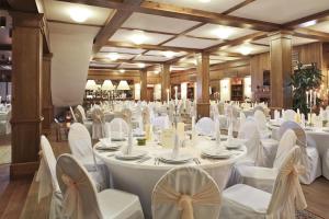 a banquet hall with white tables and white chairs at Green Life Boutique Apartments in Bansko