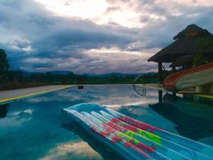 a swimming pool with blue water and a umbrella at Kuad Khon Thoe Pai Cottage in Pai