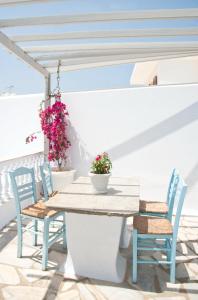a table and chairs on a patio with flowers at Nikoleta Rooms in Tinos