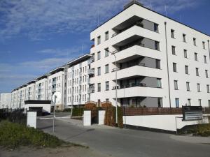 duży biały budynek apartamentowy przy ulicy w obiekcie Sunshine Rooms w Gdańsku