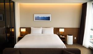 Postel nebo postele na pokoji v ubytování Ramada Encore by Wyndham Busan Haeundae