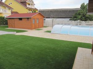 einen Garten mit einem Gebäude und einem Grasfeld in der Unterkunft Villa Jäger in Vonyarcvashegy