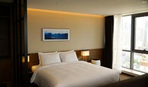 Postel nebo postele na pokoji v ubytování Ramada Encore by Wyndham Busan Haeundae