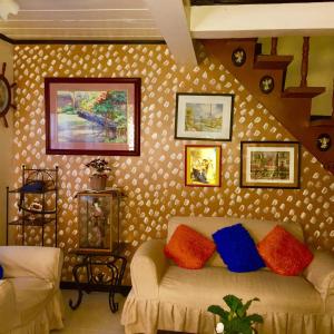 a living room with a couch and pictures on the wall at Entire House with 4 rooms near SM Molino and Vermosa Ayala in Imus