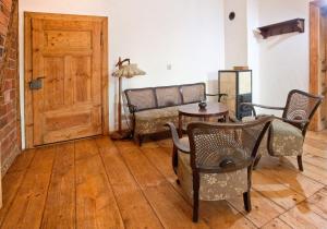 - un salon avec un canapé, des chaises et une table dans l'établissement Gosciniec Kaszarnia Kamienne, à Mirsk