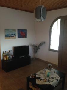 uma sala de estar com uma mesa e uma televisão em Villa Niki em Neos Marmaras