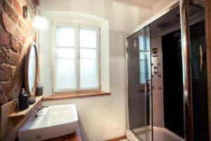 baño con lavabo, ducha y ventana en Gosciniec Kaszarnia Kamienne en Mirsk