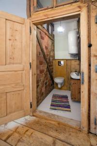 a bathroom with a toilet and a sink and a door at Gosciniec Kaszarnia Kamienne in Mirsk