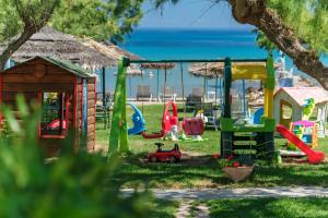 a playground with a toy car in the grass at Fiore Beach Studios in Vasilikos