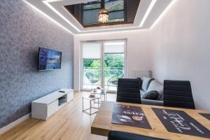 a living room with a table and chairs and a couch at Apartament Marina Przy Porcie Nad Niegocinem in Giżycko