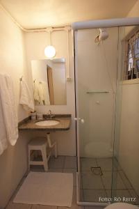 a bathroom with a shower and a sink and a mirror at Pousada Casa de Praia in Florianópolis +26 photos