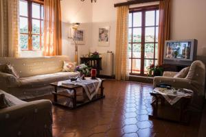 a living room with couches and tables and windows at Alexandra Villa Stalos in Stalos