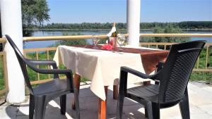 Kozloduy的住宿－Хотелски комплекс Радецки град Козлодуй，一张带白色桌布的桌子和两把椅子