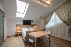 1 dormitorio con cama, mesa y TV en Wiktoria, en Wisła