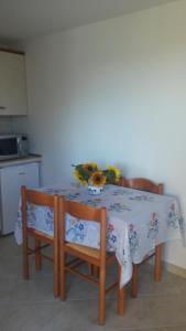 a table with two chairs and a table with flowers on it at House Barizoni in Ankaran +19 photos