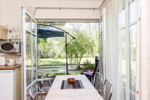 a kitchen and dining room with a table and a large window at Vila Claudia in Palanga