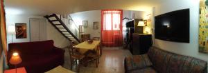 a living room with a couch and a table and a television at Casa e Giardino in San Giovanni la Punta