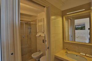 a bathroom with a sink and a toilet and a mirror at BdL Open Space in Marsala +40 photos